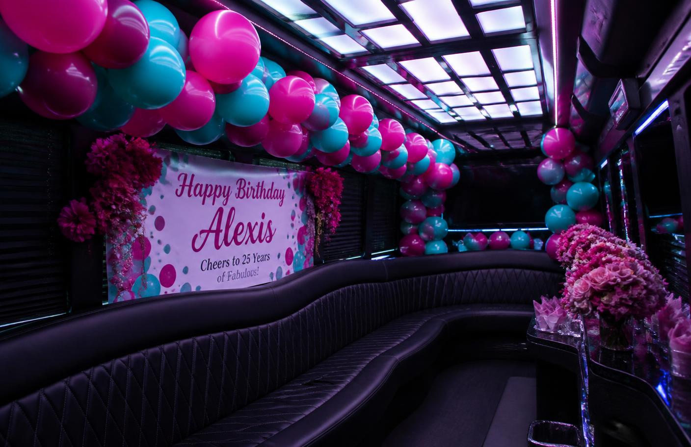 Party bus interior decorated with a balloon garland, banner and flowers
